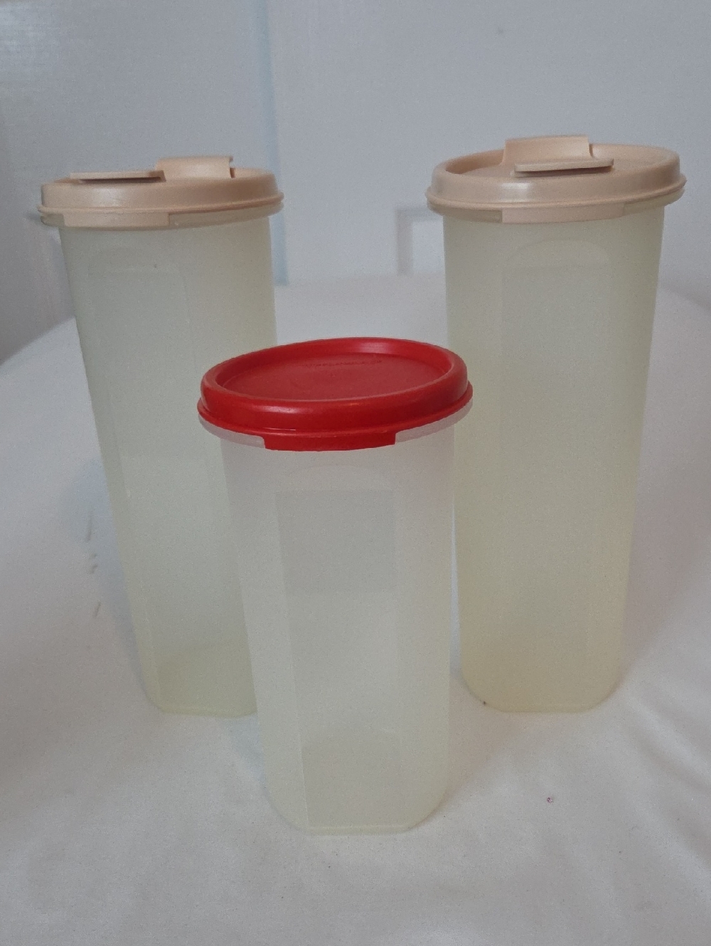 Tupperware translucent canisters with red and beige lids